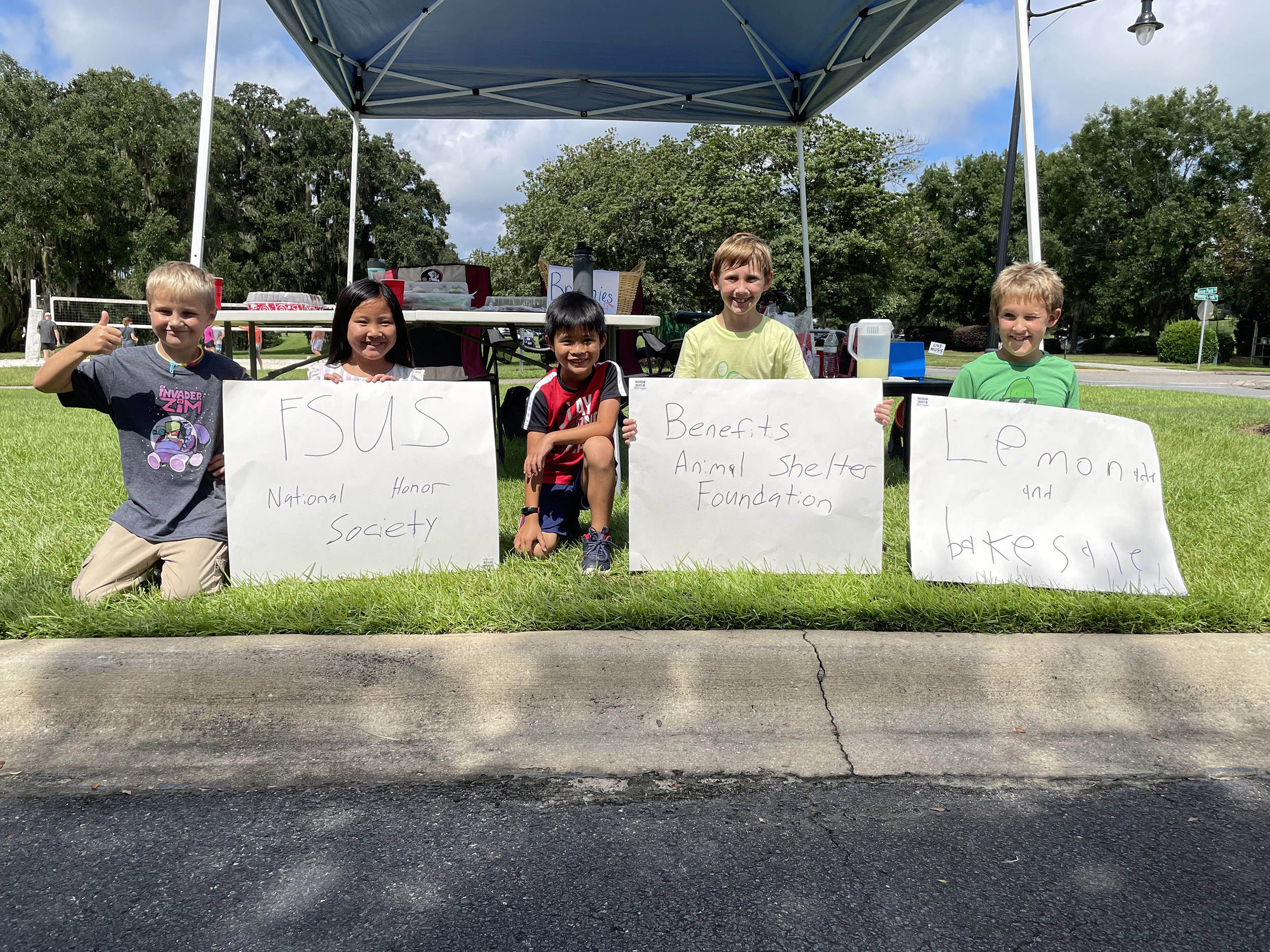 photo of children with signs at fundraising lemonade stand